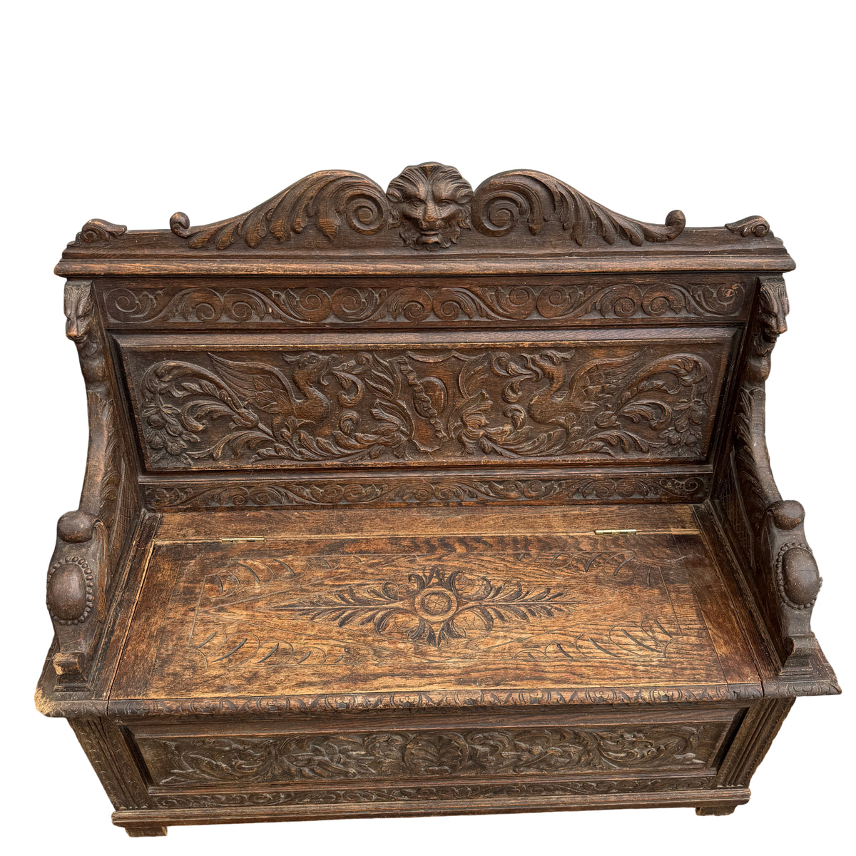Full view of carved oak monks bench with storage in aged dark finish