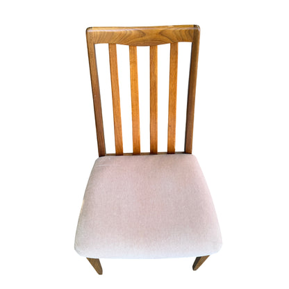 Front view of four vintage dining chairs with pale upholstered seats and wood frames