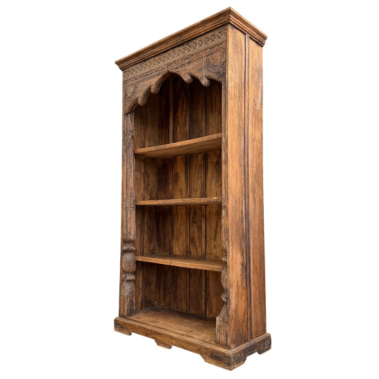Tall carved oak bookcase with open shelves and carved frieze at top