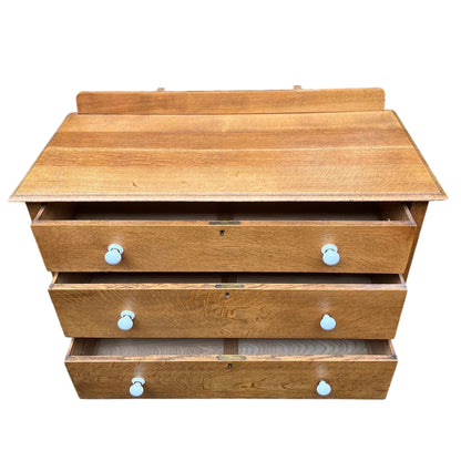Close-up of oak drawer front with quarter-sawn grain and white ceramic knob