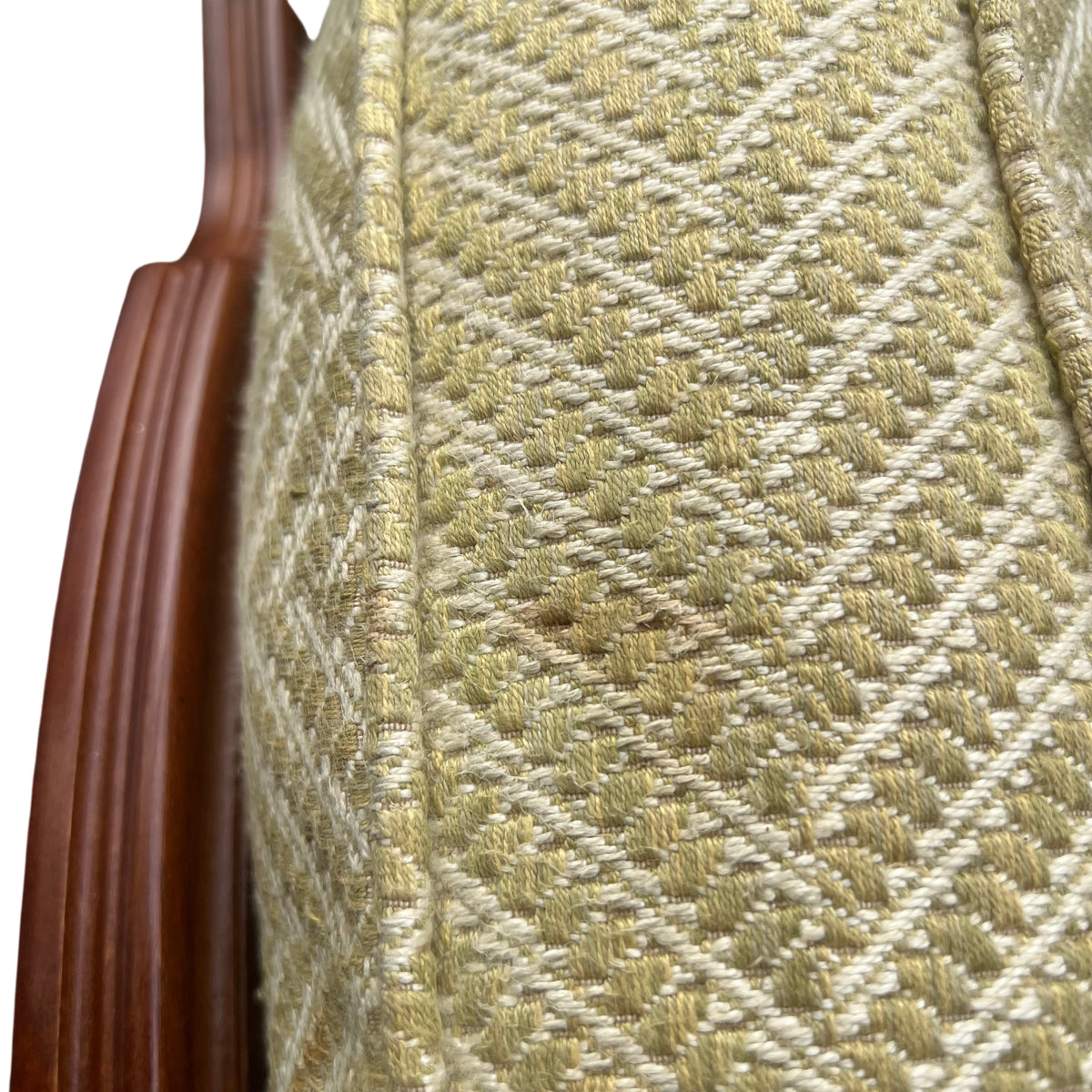 Pale yellow upholstered seat cushion on vintage cane armchair