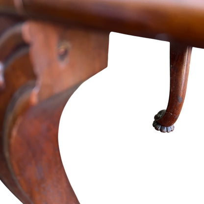 Worn finish and marks visible on carved mahogany legs of a Victorian stool