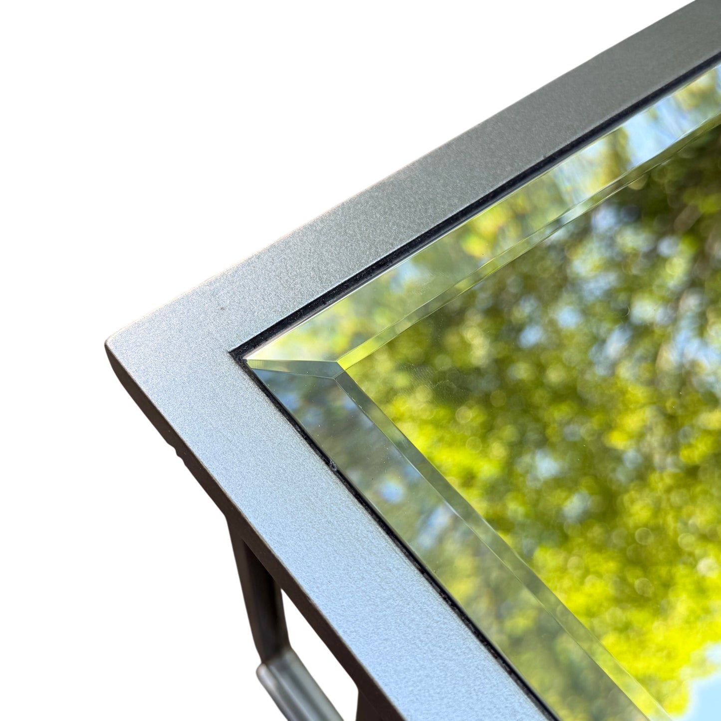 Close-up of mirrored table corner showing decorative circular mirror inset