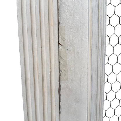 Side view of vintage painted armoire showing plain painted side and cornice profile