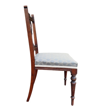 Top-down view of grey upholstered seat and carved seat rail on antique chair