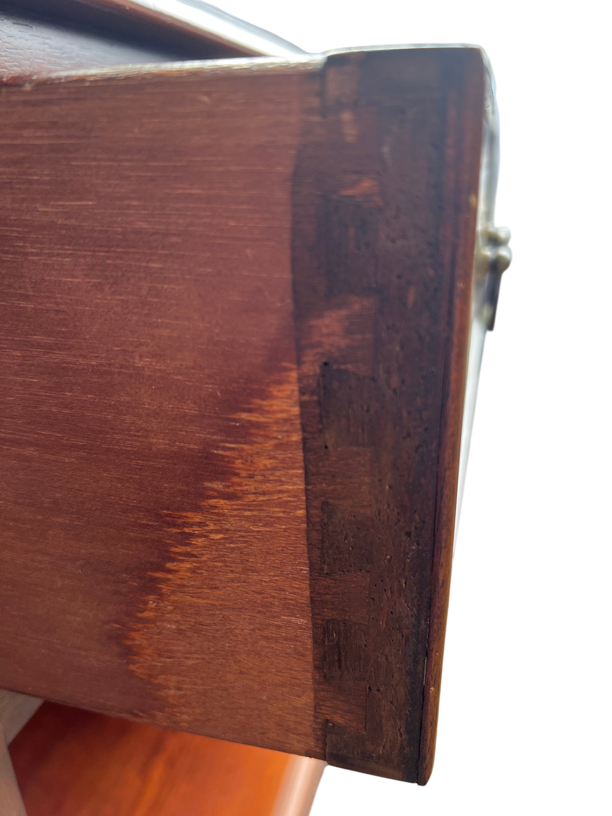 Traditional bedside cabinet showing brass bail handles and drawer front