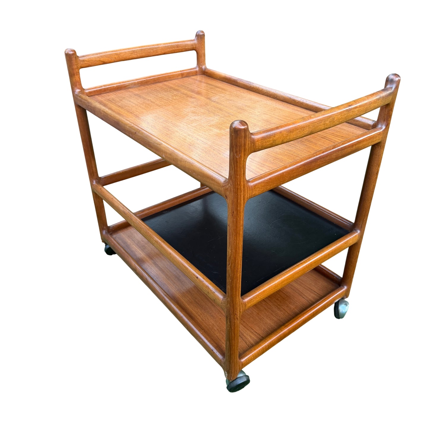 Middle black laminate shelf of a Danish teak trolley with ring marks
