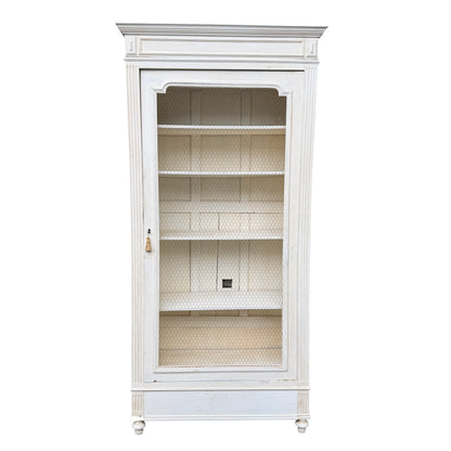 Front view of vintage French painted display cabinet with wire mesh door and interior shelves
