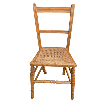 Front view ladderback dining chair with caned seat and turned legs