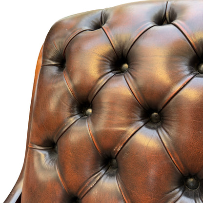 Full front view of brown leather slipper armchair showing seat and back tufting