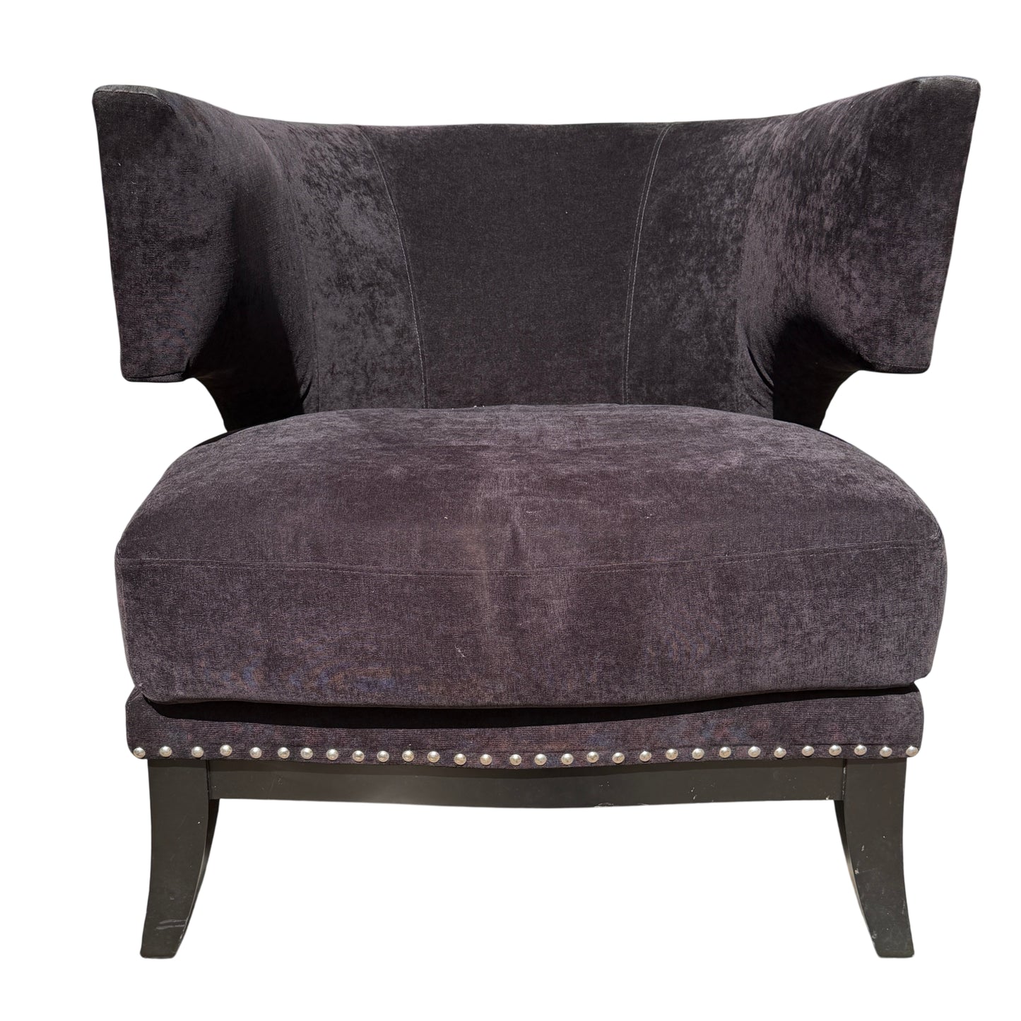 Front corner of upholstered armchair showing removable seat cushion and stud detail