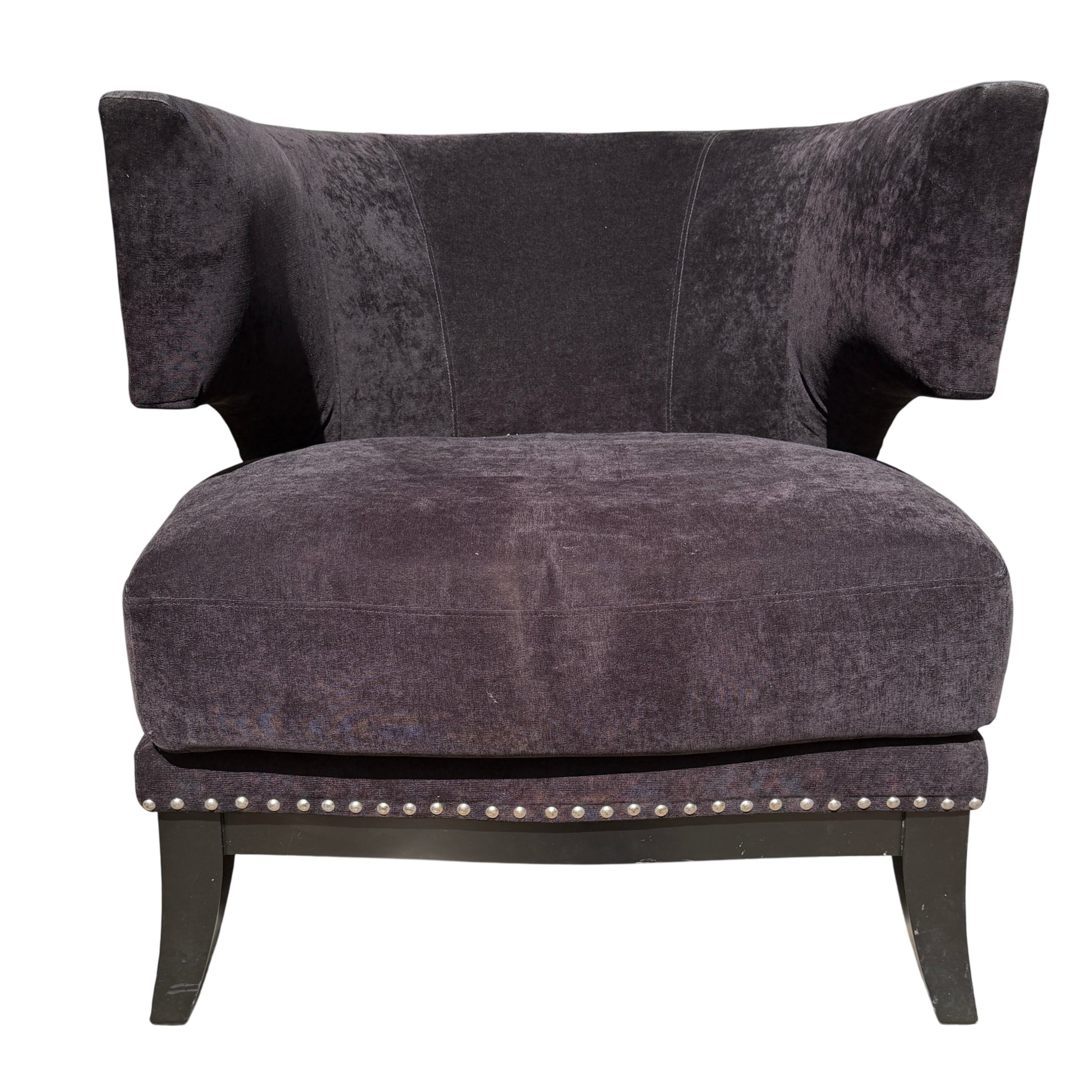 Front corner of upholstered armchair showing removable seat cushion and stud detail