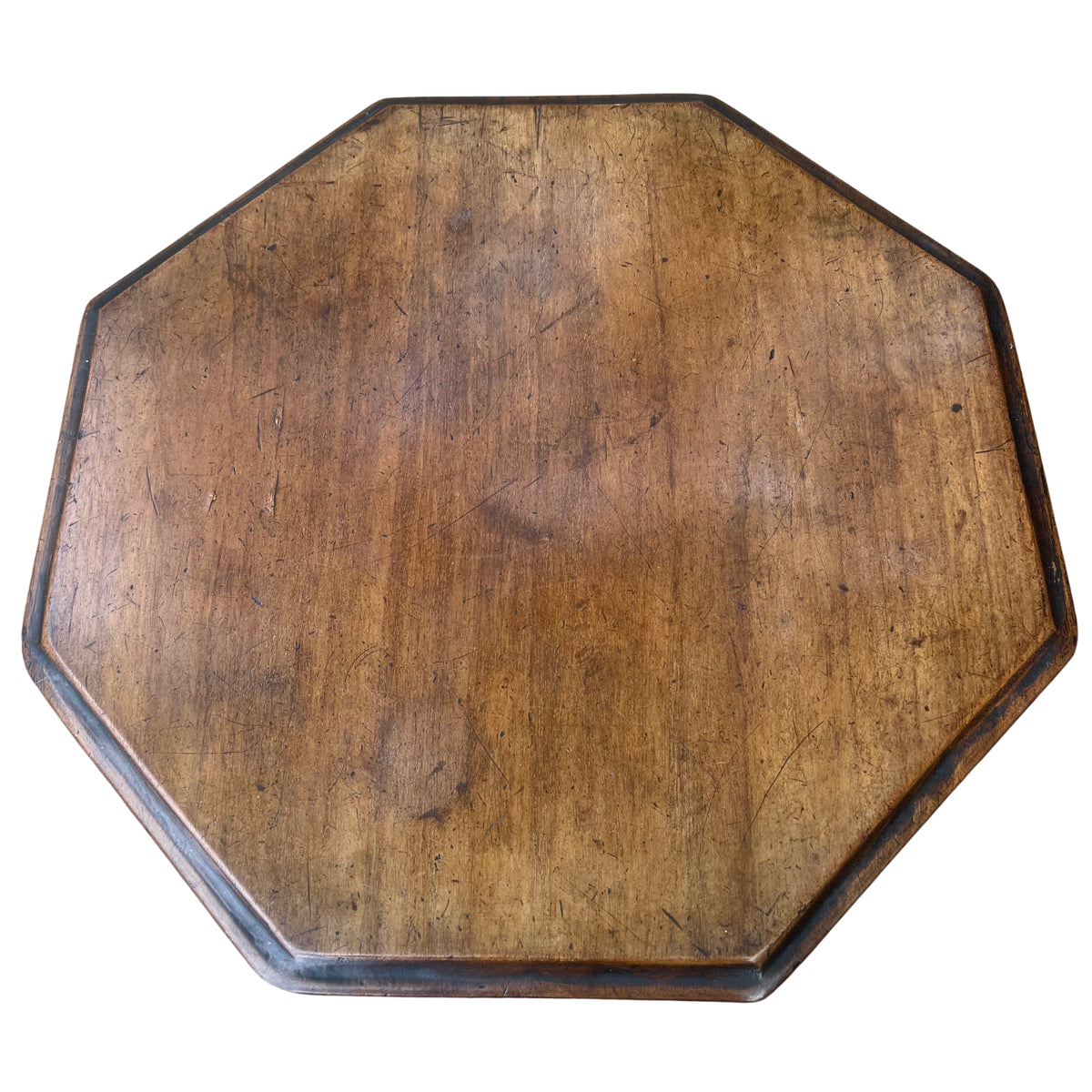 Side view showing scalloped frieze edge and thin octagonal tabletop on Victorian table