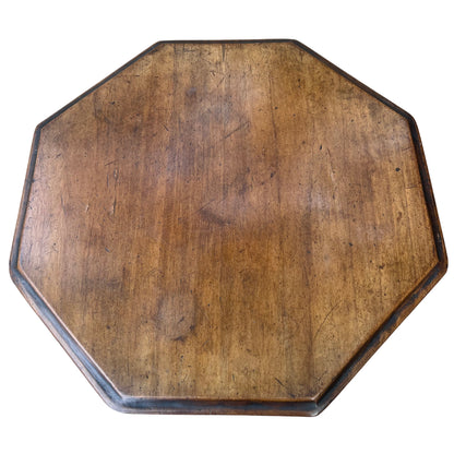 Side view showing scalloped frieze edge and thin octagonal tabletop on Victorian table