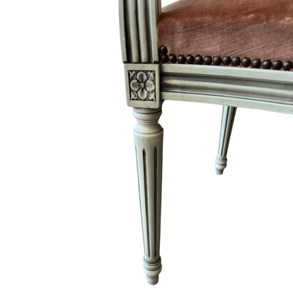 Lower frame and turned front legs of a painted vintage armchair with carved floral corner block