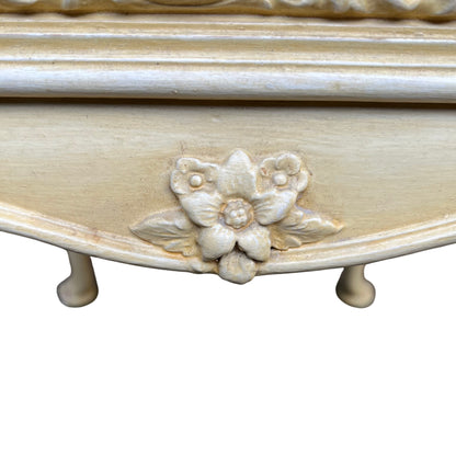 Detail of carved cabriole leg and floral carved knee on painted bedside cabinet