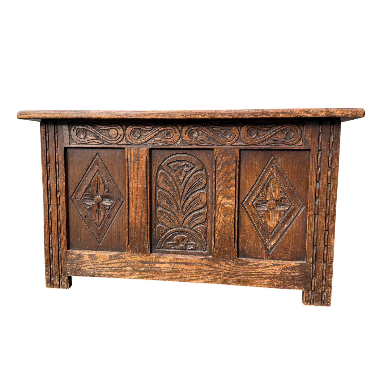 Close-up of carved oak panel showing floral and geometric carving detail
