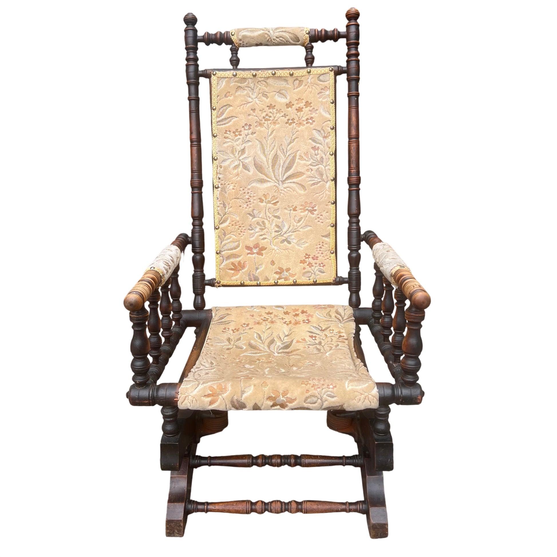 Front view of Victorian rocking armchair with brass nailhead trim and turned spindles