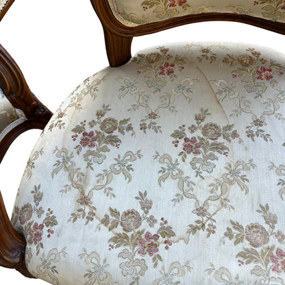 Top view of bergère chair back showing trimmed upholstery and carved wooden crest