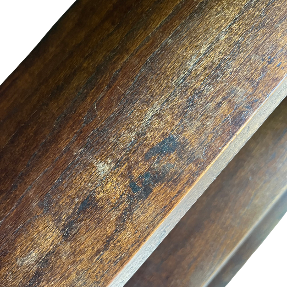 Full height view of tall narrow oak bookshelf standing outdoors