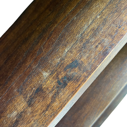Full height view of tall narrow oak bookshelf standing outdoors
