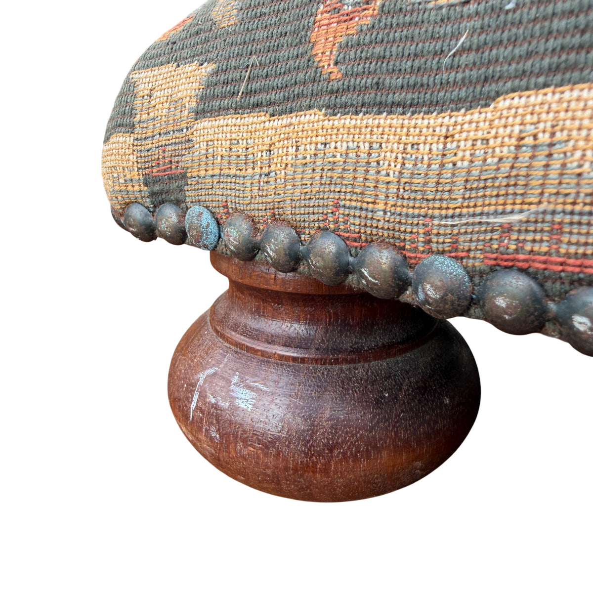 Edge of footstool showing decorative nails and woven tapestry upholstery