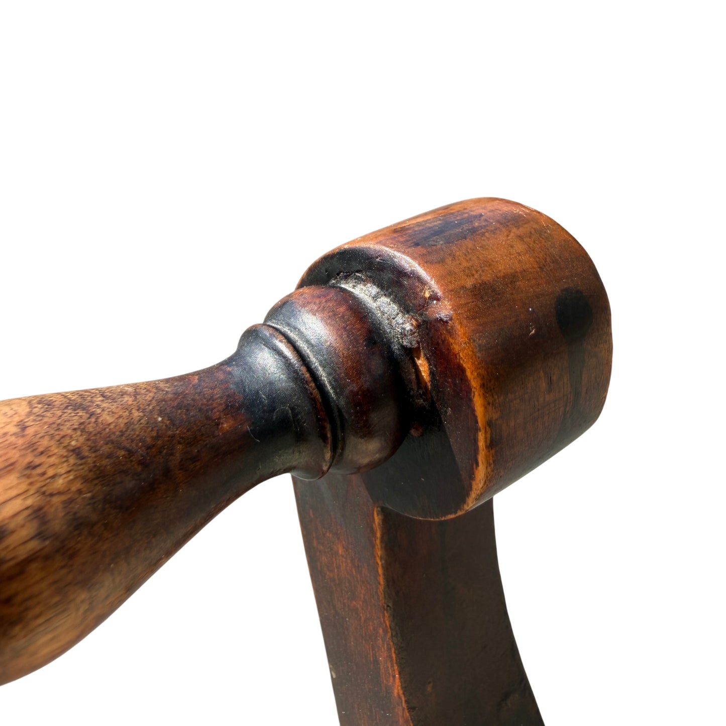 View of one shaped leg and foot of a Victorian stool showing scuffing at the base
