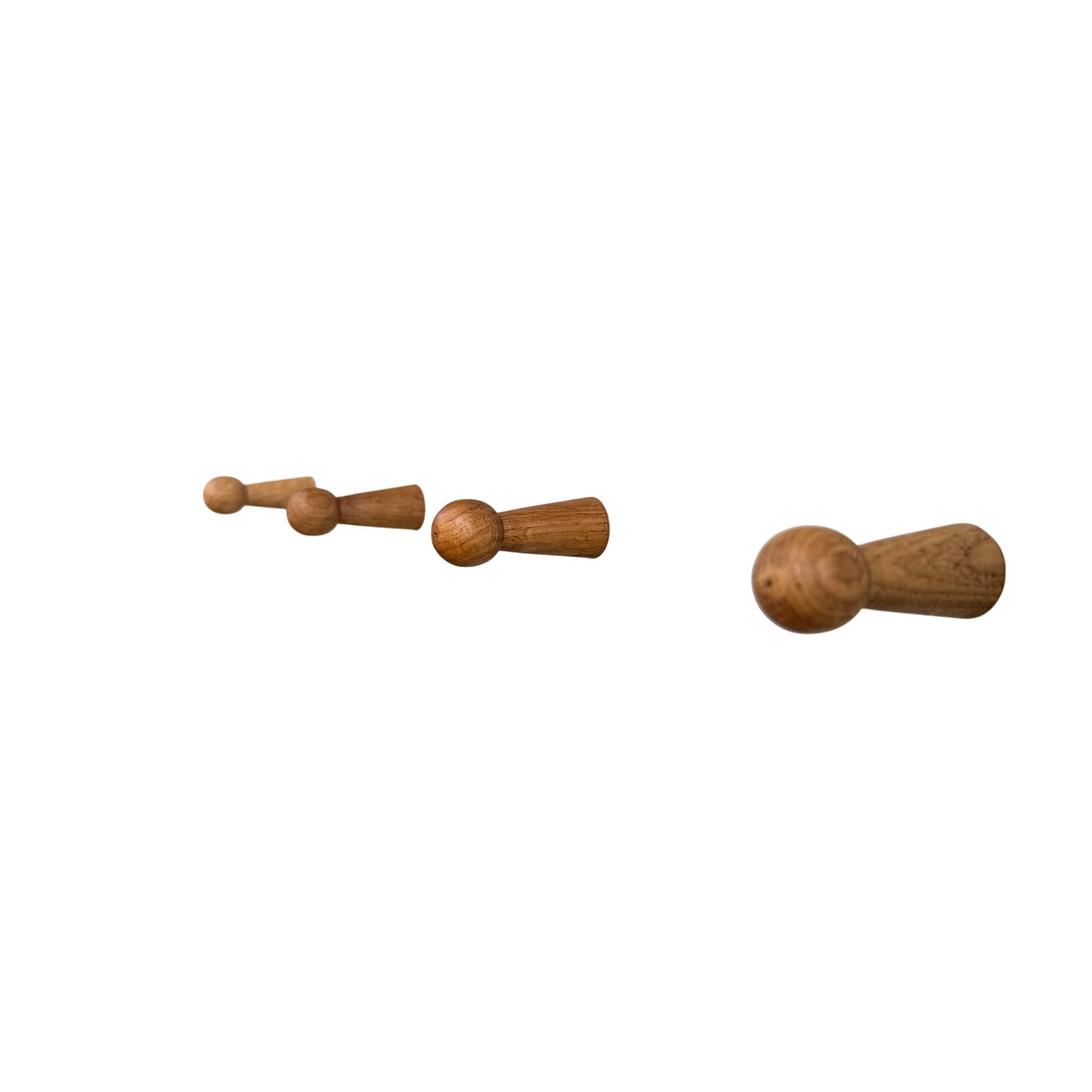 Detail of four wooden coat pegs mounted on painted backboard of hall bench