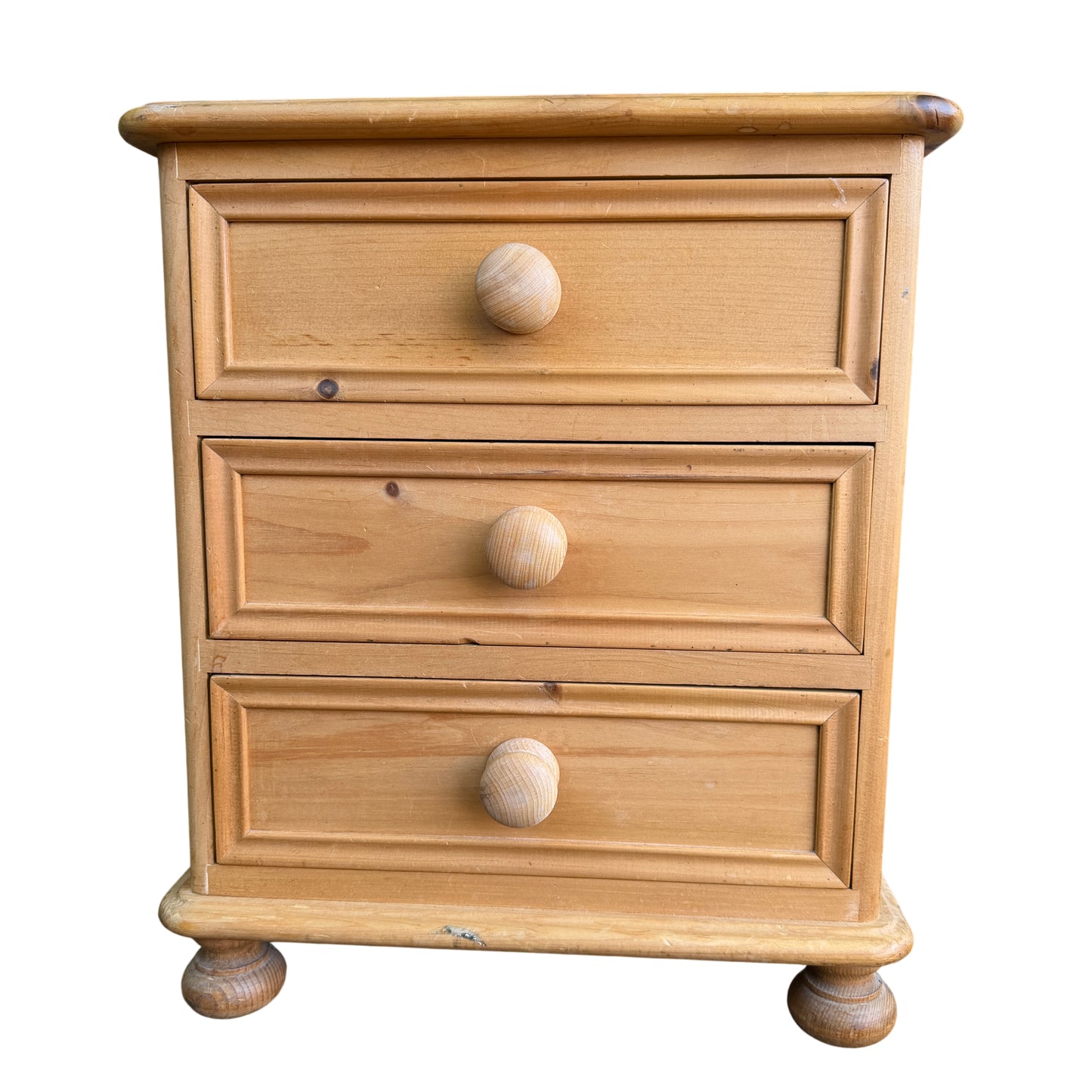 Close-up of top drawer and turned wooden knob on pine bedside cabinet