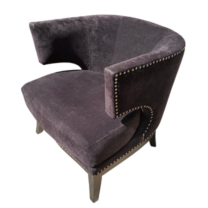Large rounded seat cushion of black velvet-effect armchair with timber legs