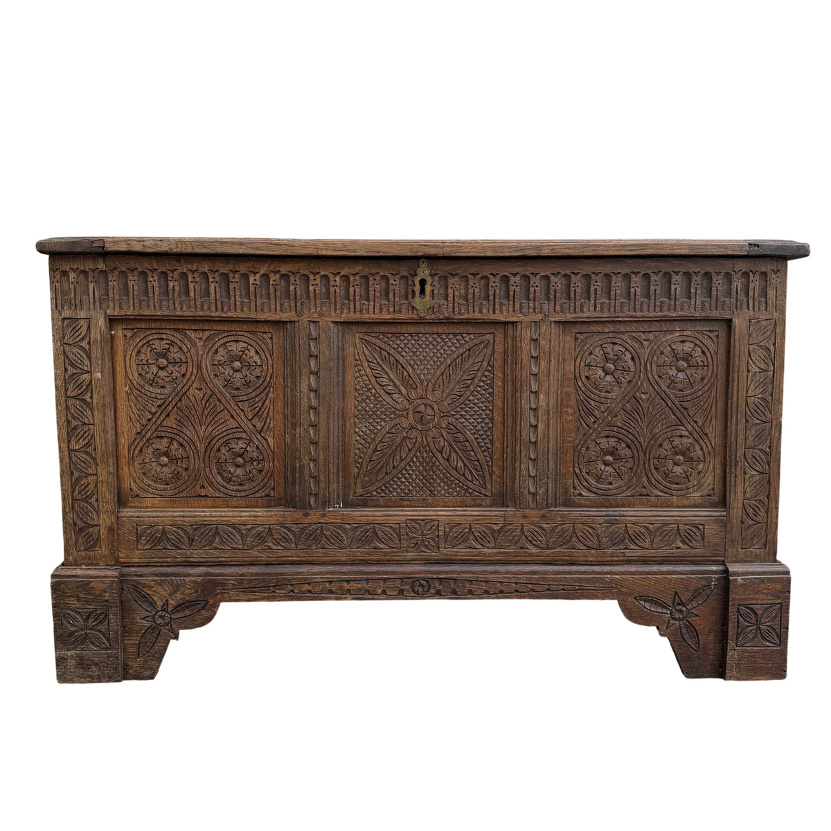 Front view carved oak chest with roundel floral carvings and geometric panels