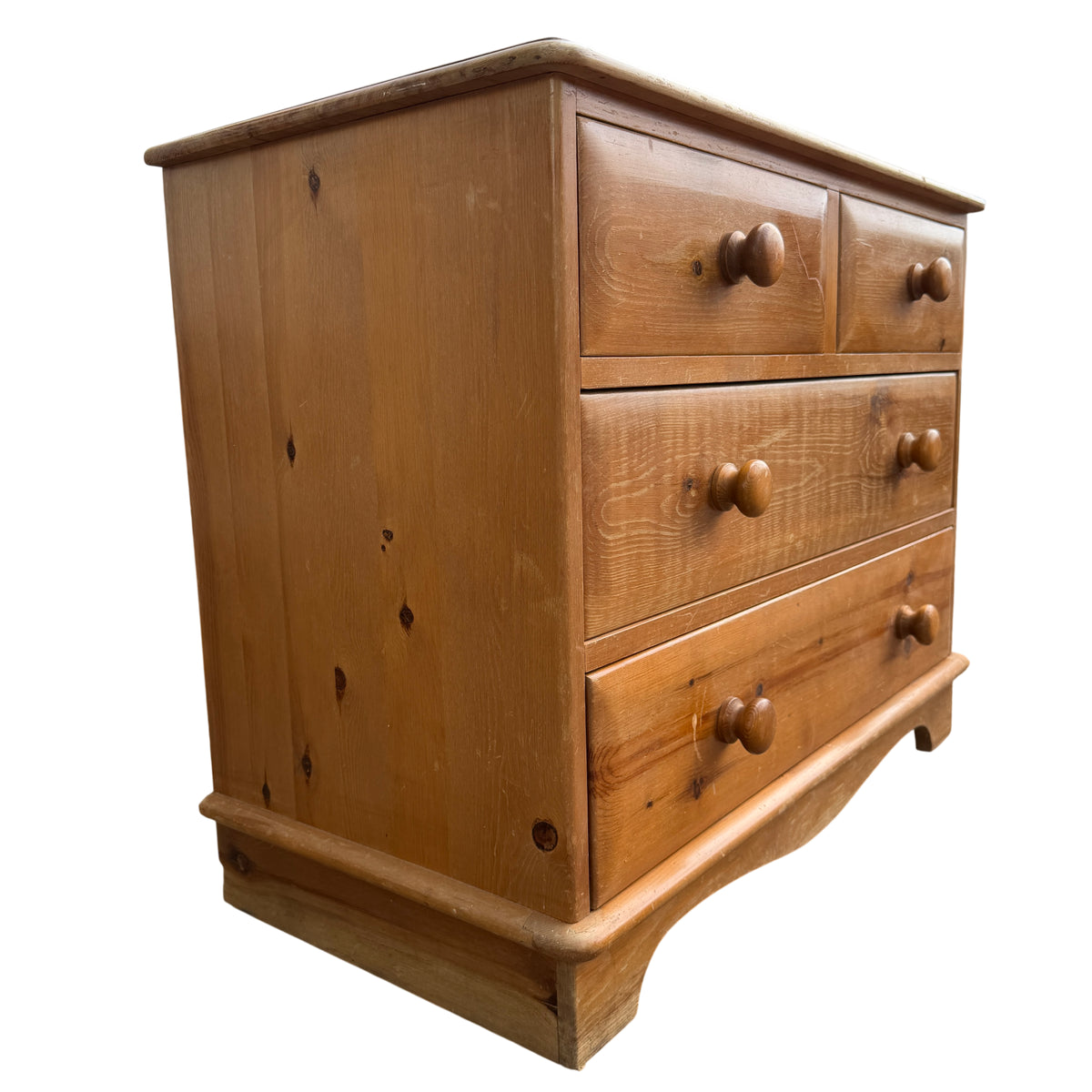 Base and feet of pine chest showing shaped plinth and edge wear