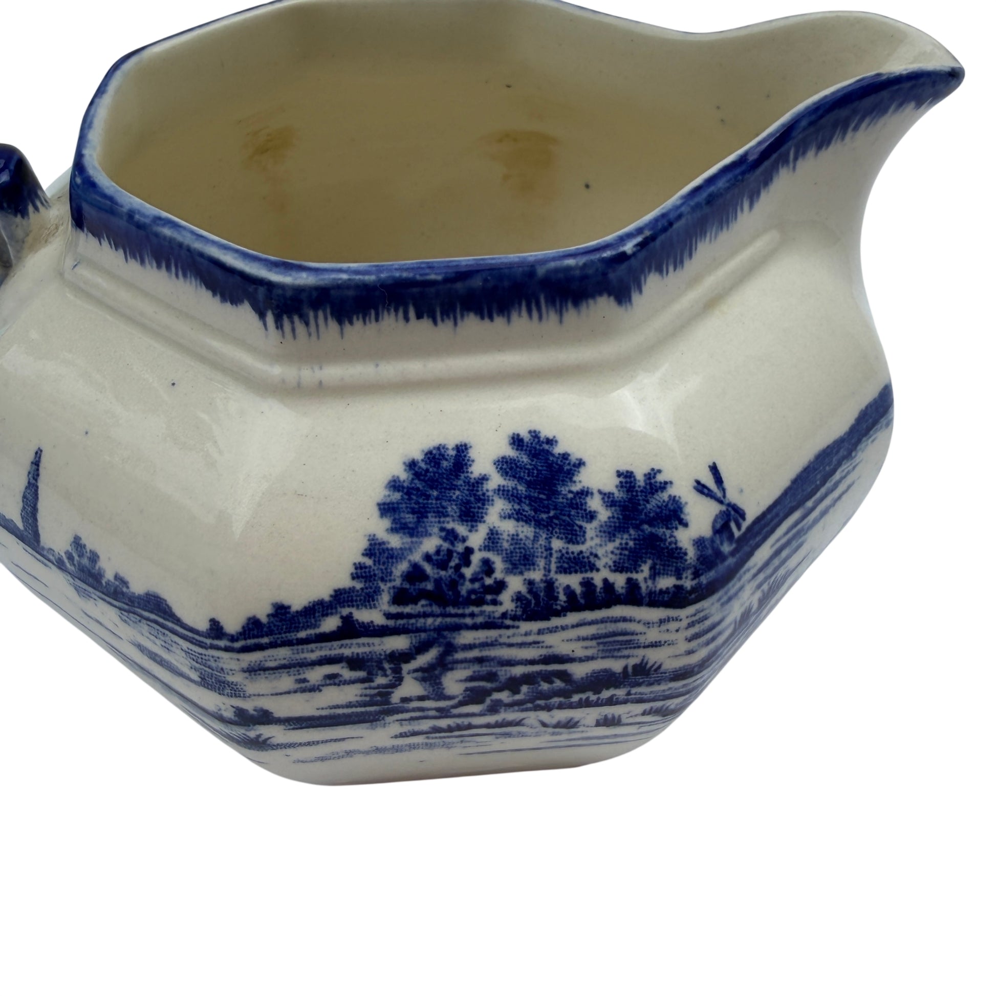 Side view of antique blue and white transferware jug showing landscape transfer pattern