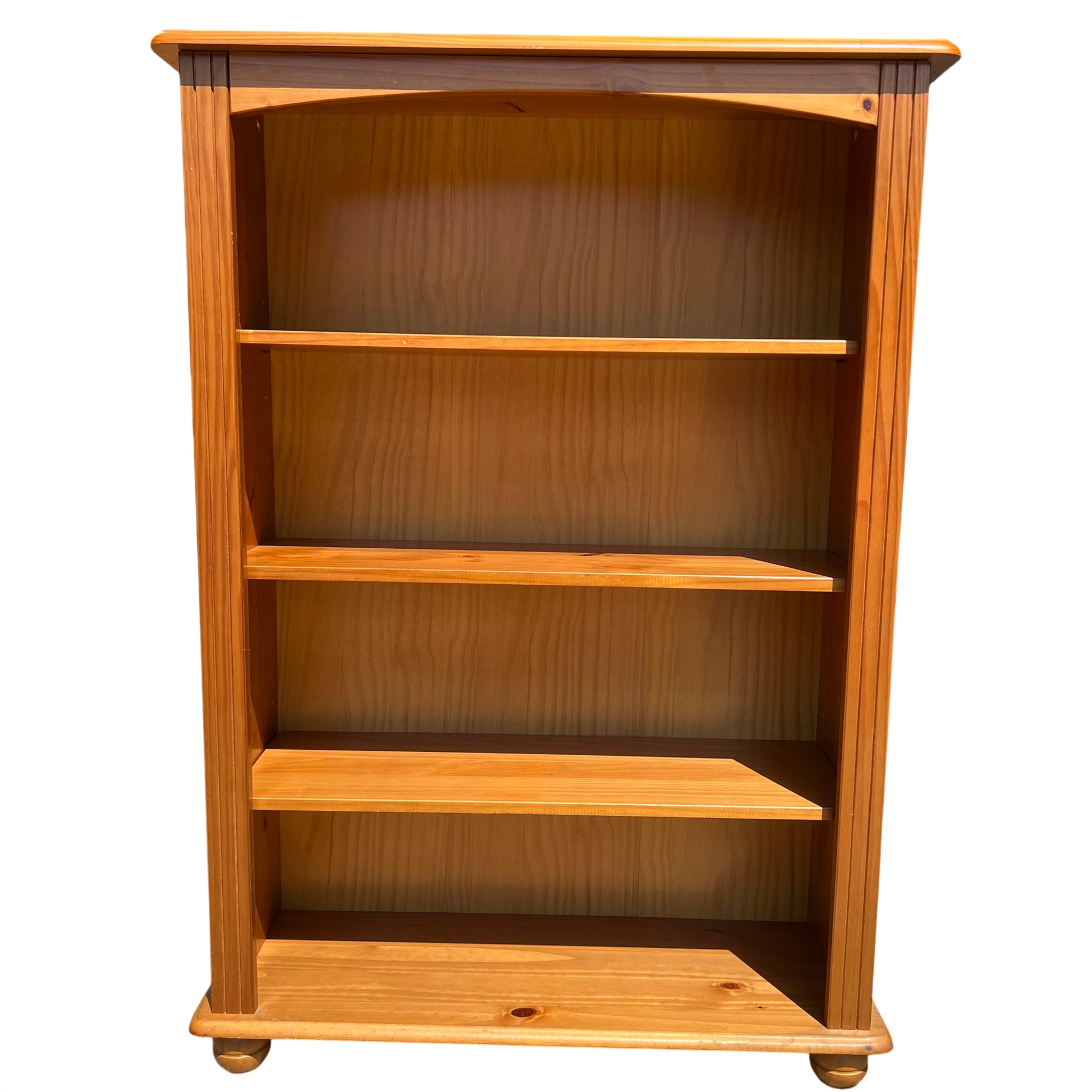 Close up of top moulded rail and curved apron on pine bookcase
