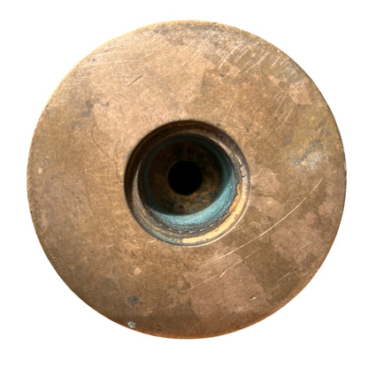 Detail of recessed grooves showing green patina on a vintage brass candlestick stem