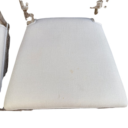 Two rattan back dining chairs shown side by side with upholstered seats