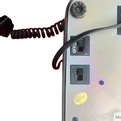 Retro black telephone handset resting on cradle with coiled cable