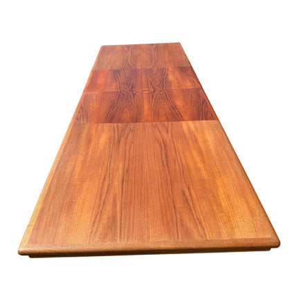 Dining table set out on pavement among other secondhand furniture items