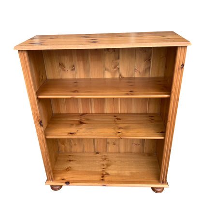 Vintage pine bookcase with three shelves, panelled back and turned bun feet
