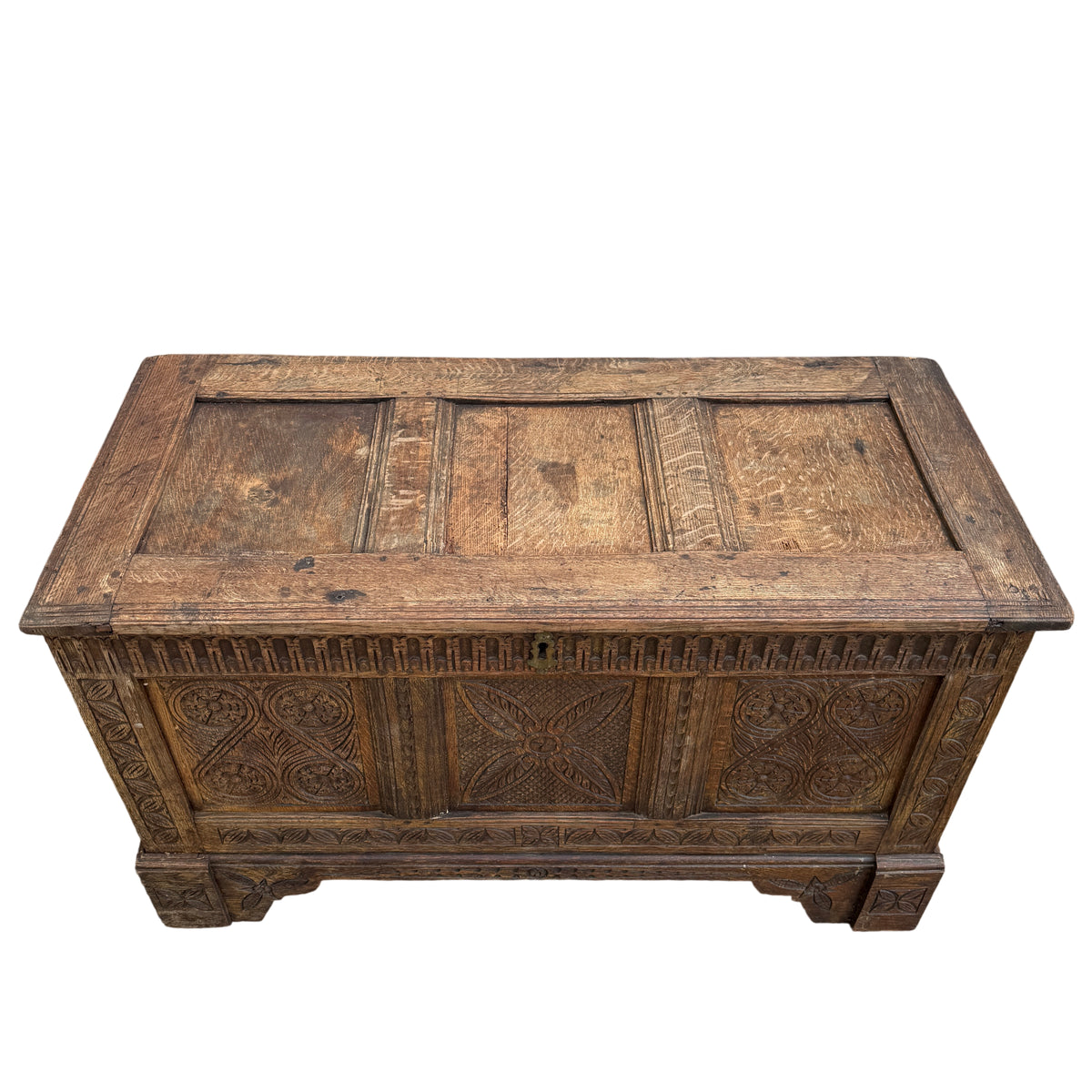 Close-up of carved panel detailing on oak coffer chest showing foliate motifs