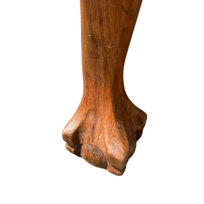 Side profile showing carved cabriole leg and arm of caned armchair