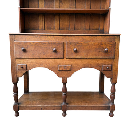 Close up of oak dresser showing two larger drawers with round wooden knobs