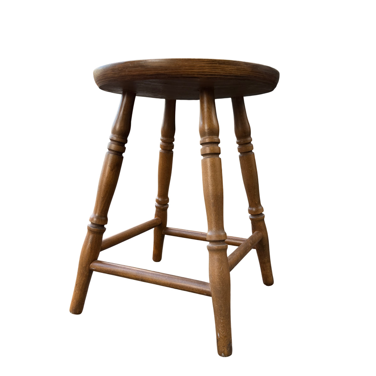 Round wooden stool top showing grain and circular edge with warm natural finish
