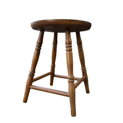 Round wooden stool top showing grain and circular edge with warm natural finish
