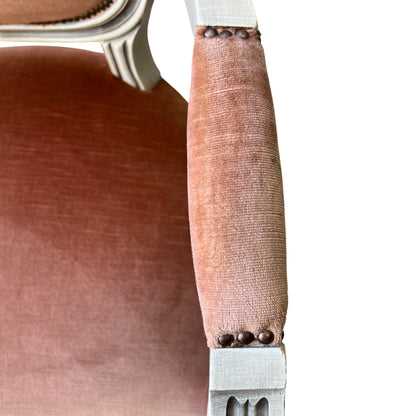 Seat cushion in peach velvet showing worn fabric and surface wear on vintage armchair