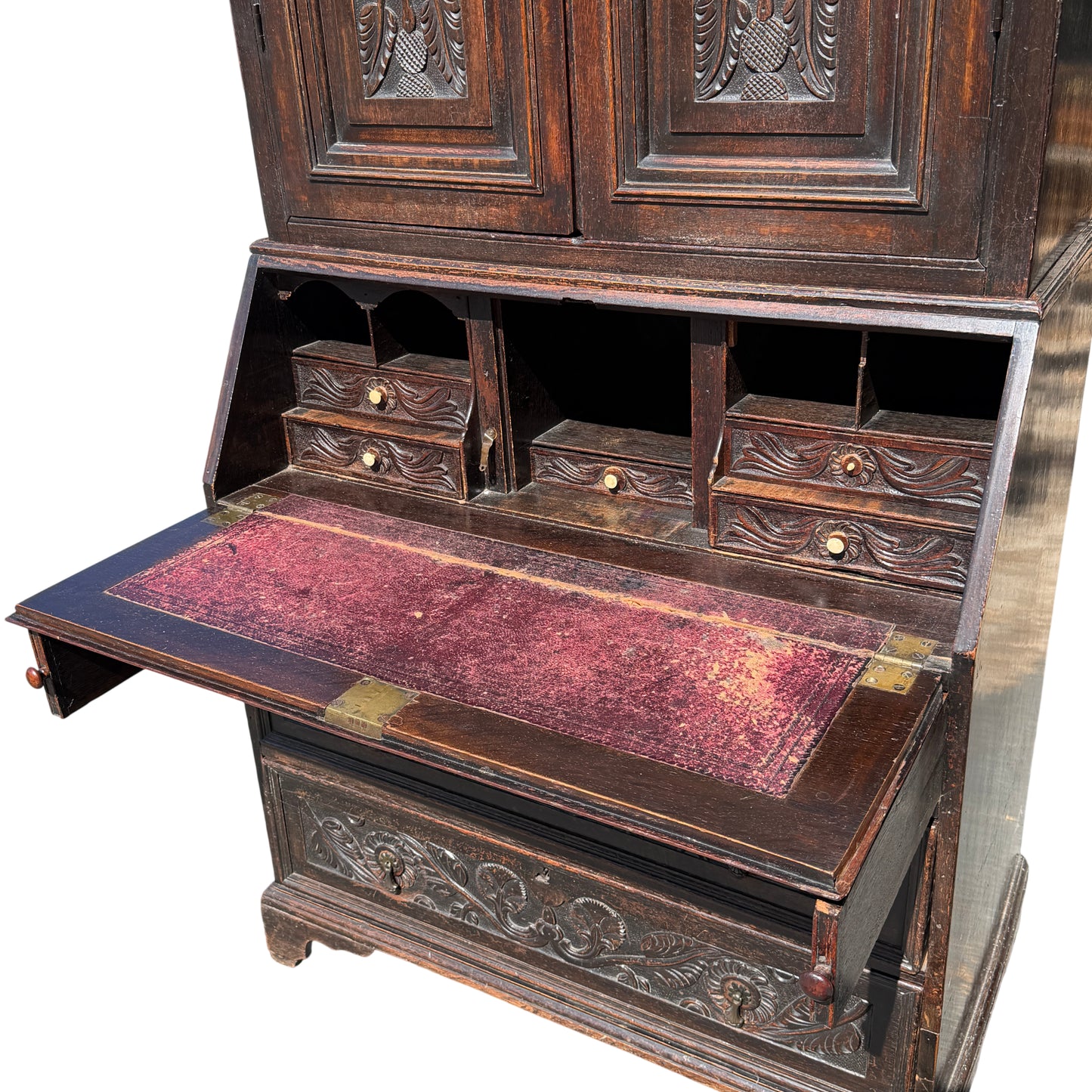 Interior fall-front writing surface with worn leather and small drawers