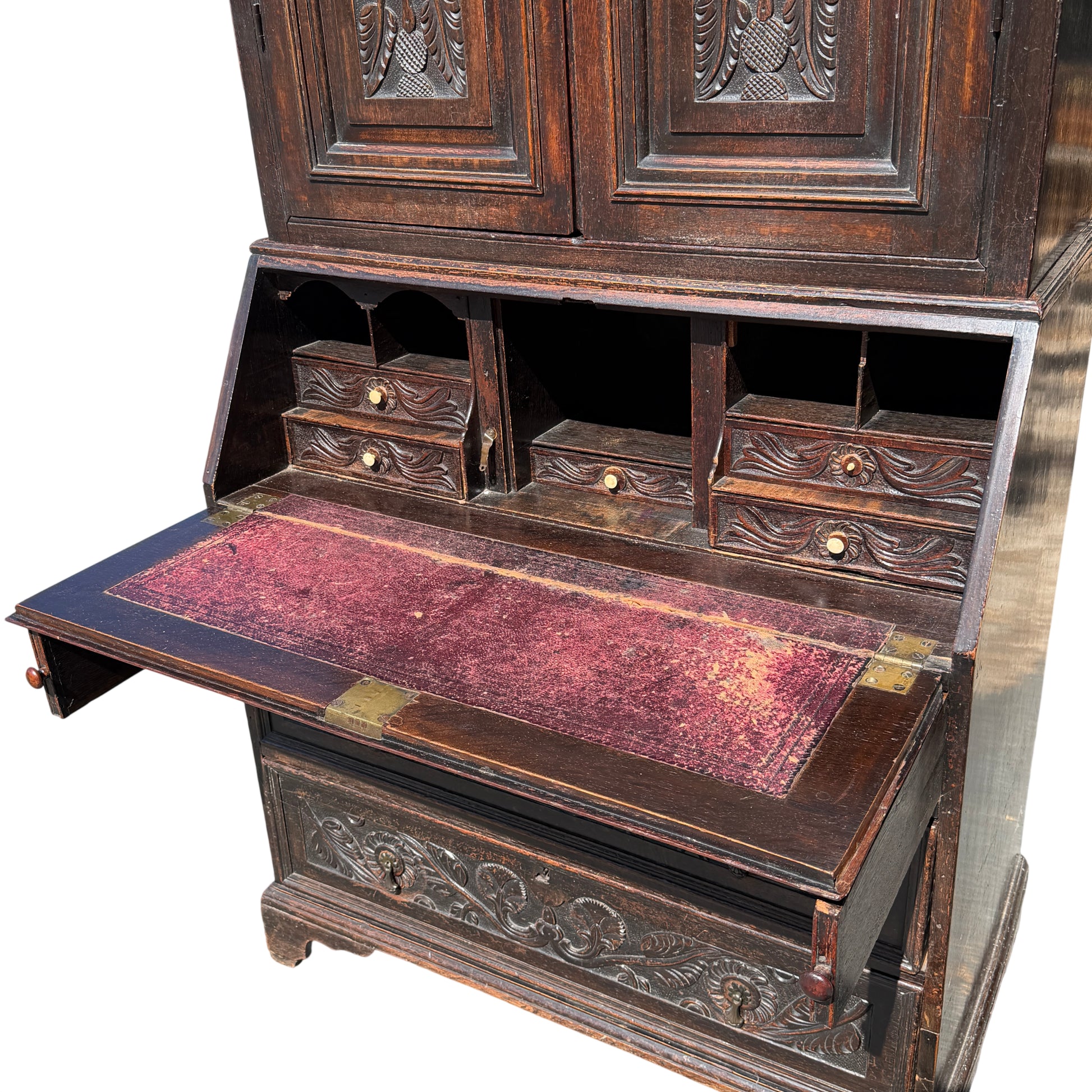 Interior fall-front writing surface with worn leather and small drawers