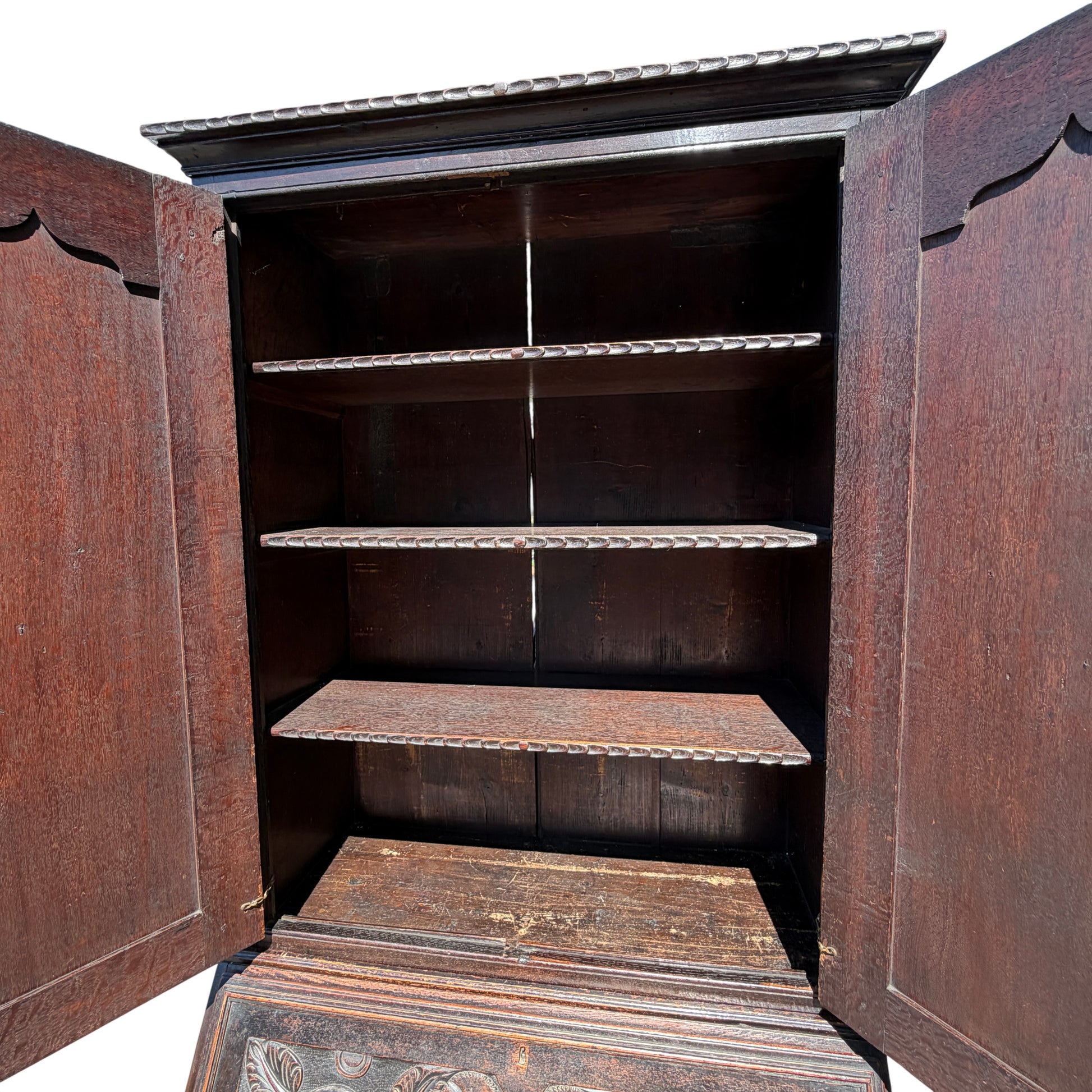 Base and bracket feet of carved oak cabinet showing wear to finish
