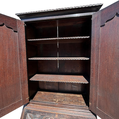 Base and bracket feet of carved oak cabinet showing wear to finish