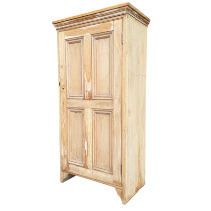 Narrow stripped pine tall cupboard with two-panel door and moulded panels